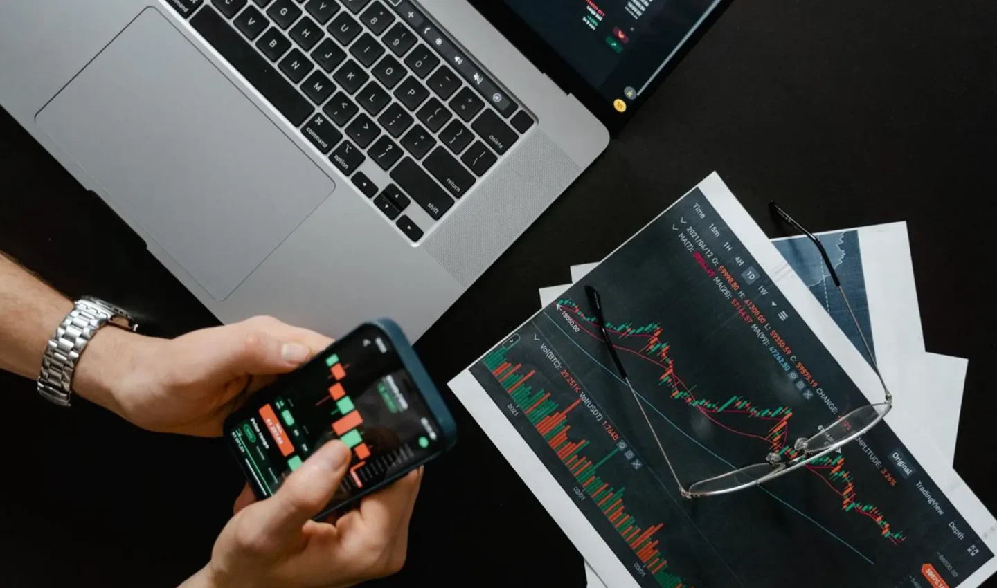Image d'une personne qui trade à l'aide de son ordinateur et de son portable